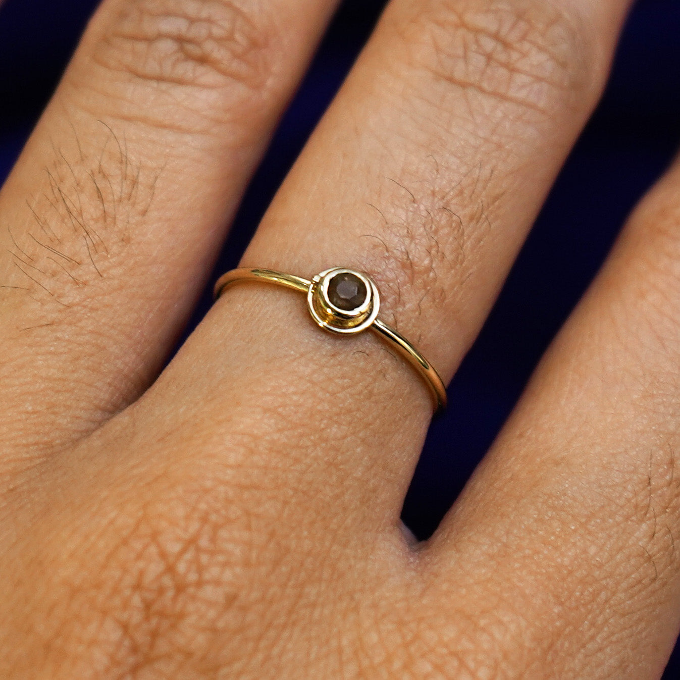 Close up view of a model's hand wearing a yellow gold Coffee Cup Ring