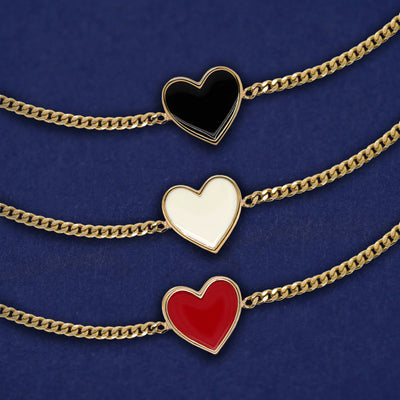 Three solid gold enamel heart bracelets shown in options of black, white, and red enamel