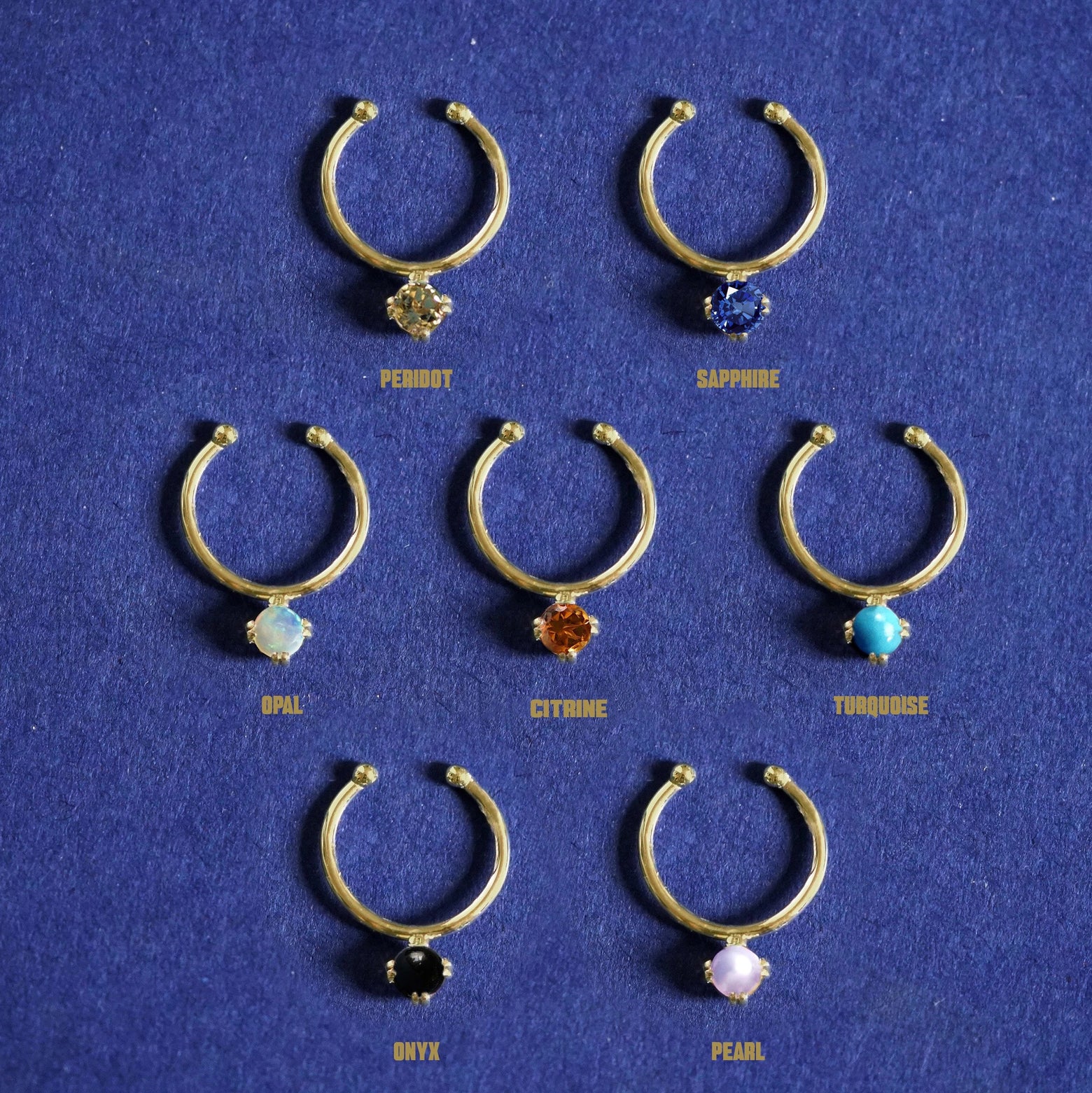 Seven versions of the Gemstone Septum shown in options of Peridot, Sapphire, Opal, Citrine, Turquoise, Onyx, and Pearl