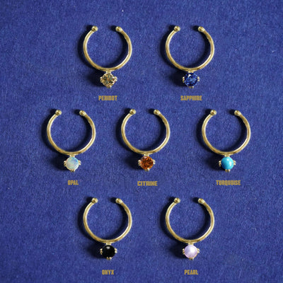 Seven versions of the Gemstone Septum shown in options of Peridot, Sapphire, Opal, Citrine, Turquoise, Onyx, and Pearl