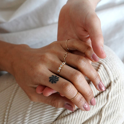 Two models holding hands while one model wears a Heart Ring, a Five Diamond Ring, and two Line Rings