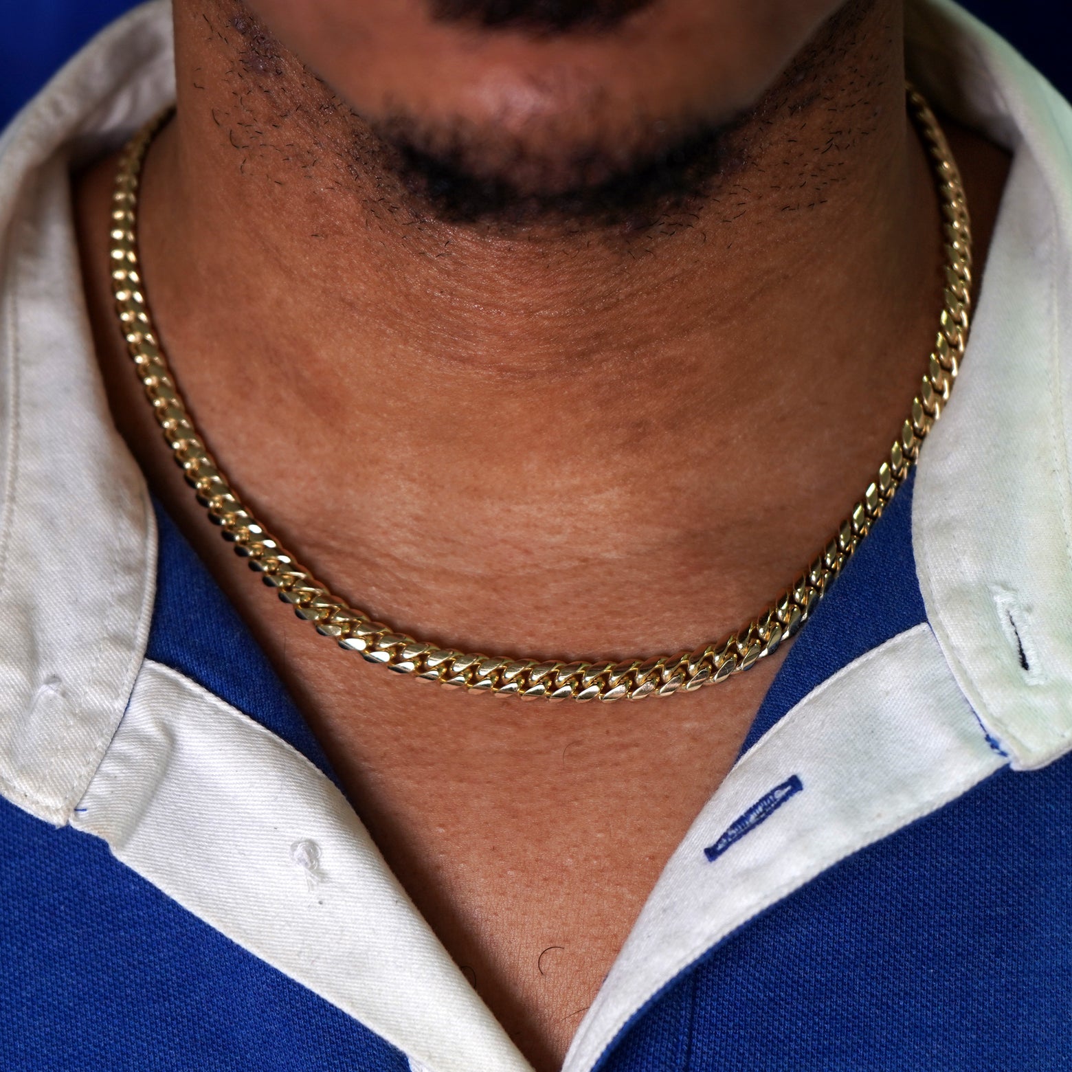 A model's neck wearing a yellow gold Miami Cuban Chain