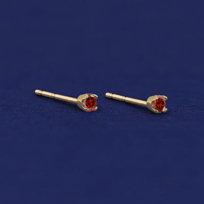 A pair of yellow gold garnet 2mm Gemstone Earrings shown with pushback posts and no backings