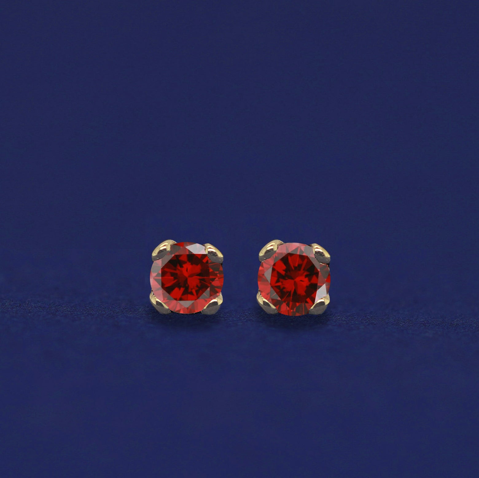 A pair of 14 karat gold studs earrings with 2 millimeter round garnets