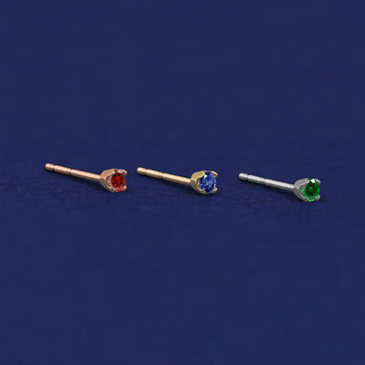 Three versions of the 2mm Gemstone Earring shown in options of rose, yellow, and white gold