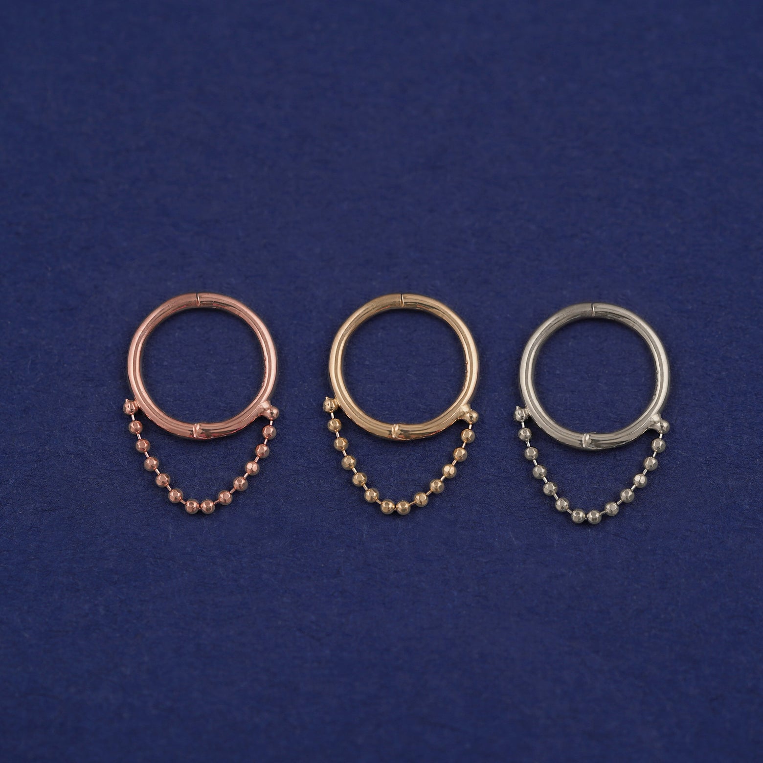 Three versions of the Beaded Huggie Earring / Piercing shown in options of rose, yellow, and white gold