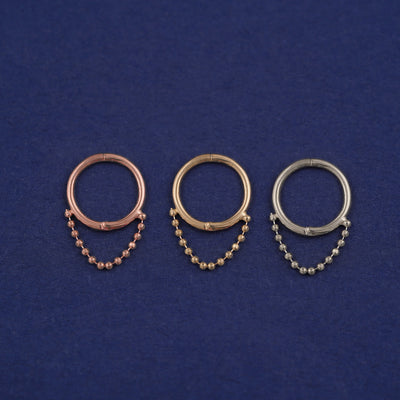 Three versions of the Beaded Huggie Earring / Piercing shown in options of rose, yellow, and white gold