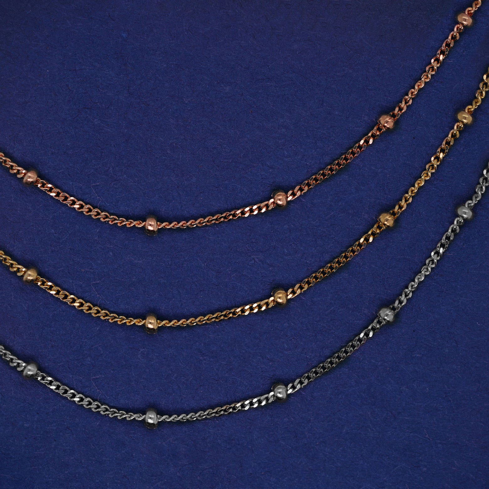 Three versions of the Beads Bracelet shown in options of rose, yellow, and white gold