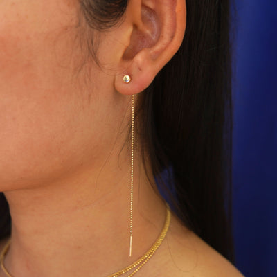 Close up view of a model's ear wearing a yellow gold Circle Threader as a dangle earring