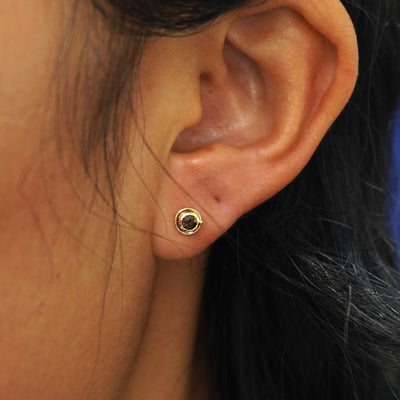A model's ear wearing a yellow gold Coffee Cup Earring