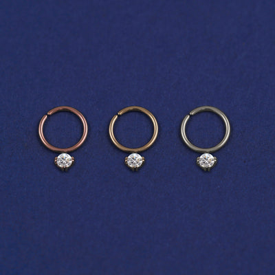Three versions of the Pierced Diamond Septum shown in options of rose, yellow, and white gold