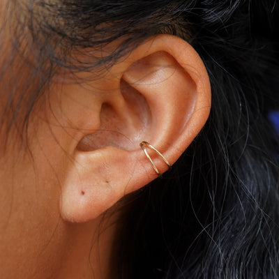 Close up view of a model's ear wearing a 14k solid gold Double Cuff