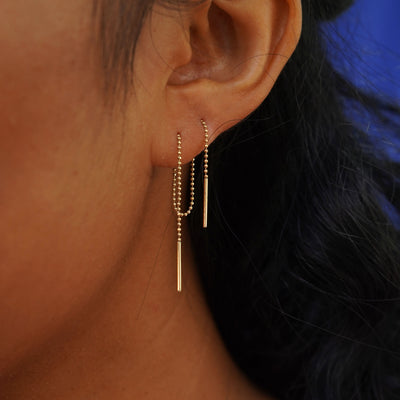 Close up view of a model's ear wearing an a Threader through two piercings to create a loop behind their ear