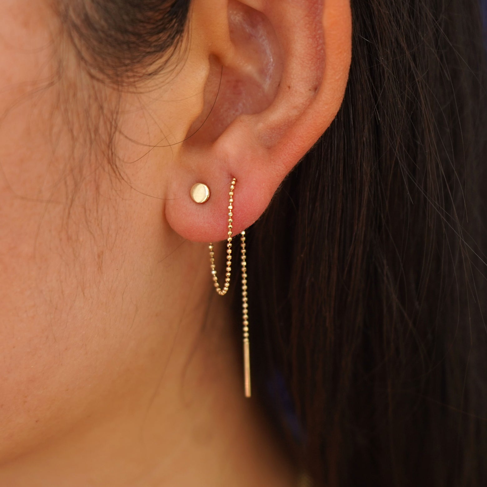 A model's ear wearing a Circle Threader looped through two piercings