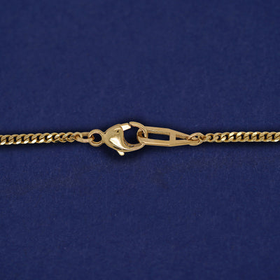 Close up view of a lobster lock and mini Miami chain on a yellow gold Enamel Heart Bracelet