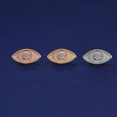 Three versions of the Diamond Evil Eye Earring shown in options of rose, yellow, and white gold