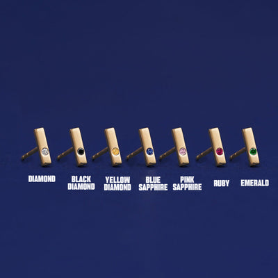 Seven versions of the Gemstone Bar Earring showing all the gemstone options laid out on a dark blue background