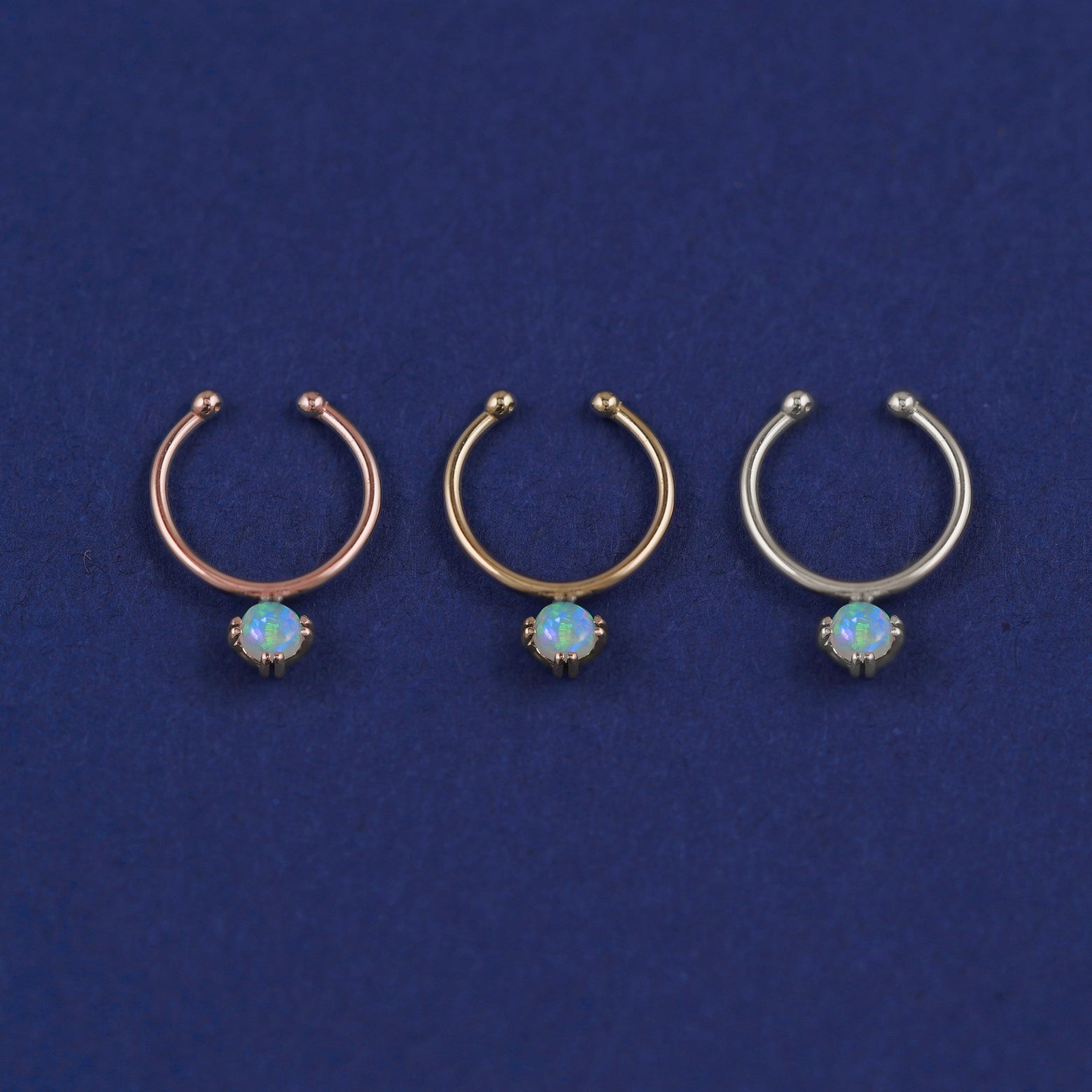 Three versions of the opal Non-Pierced Gemstone Septum shown in options of rose, yellow, and white gold