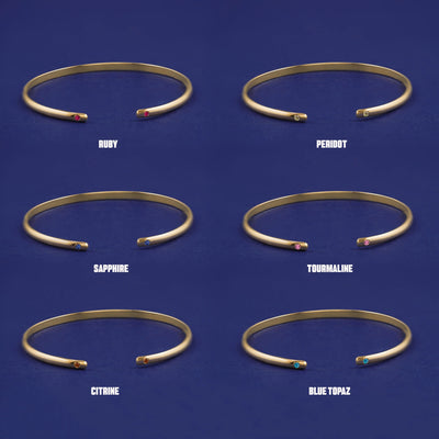 Six versions of the solid yellow gold Gemstone Open Bangle showing 6 different birthstone options