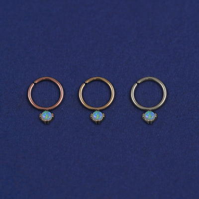 Three versions of the opal Pierced Gemstone Septum shown in options of rose, yellow, and white gold