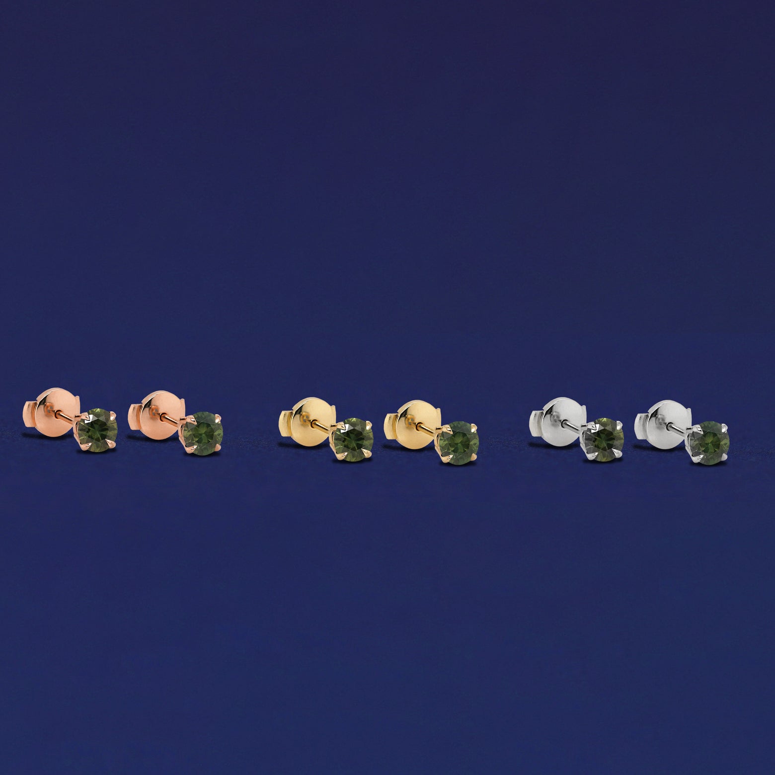 Three pairs of Green Sapphire Pressure Lock Earrings shown in options of rose, yellow, and white gold