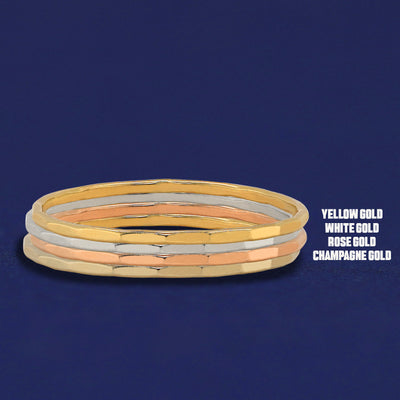 Four versions of the Hammered Ring shown in options of champagne, white, yellow and rose gold stacked on top each other
