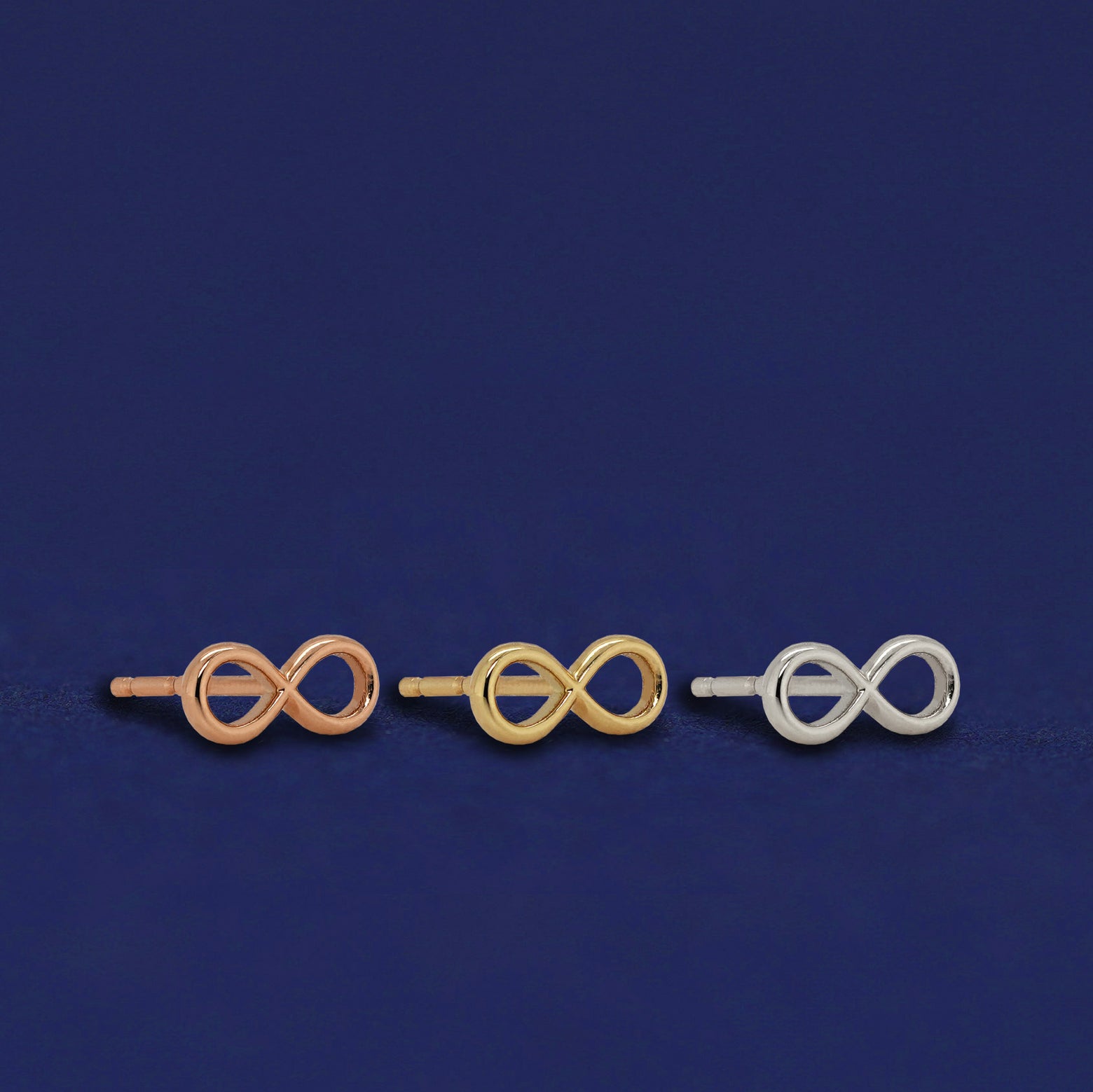 Three versions of the Infinity Earrings shown in options of rose, yellow, and white gold