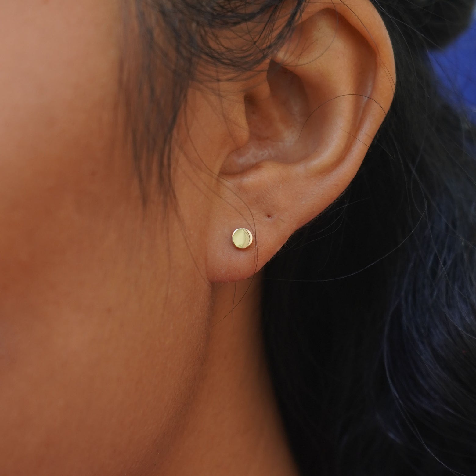 A model's ear wearing a 14k solid gold Large Circle Earring