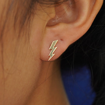 Close up view of a model's ear wearing a yellow gold Lightning Bolt Earring