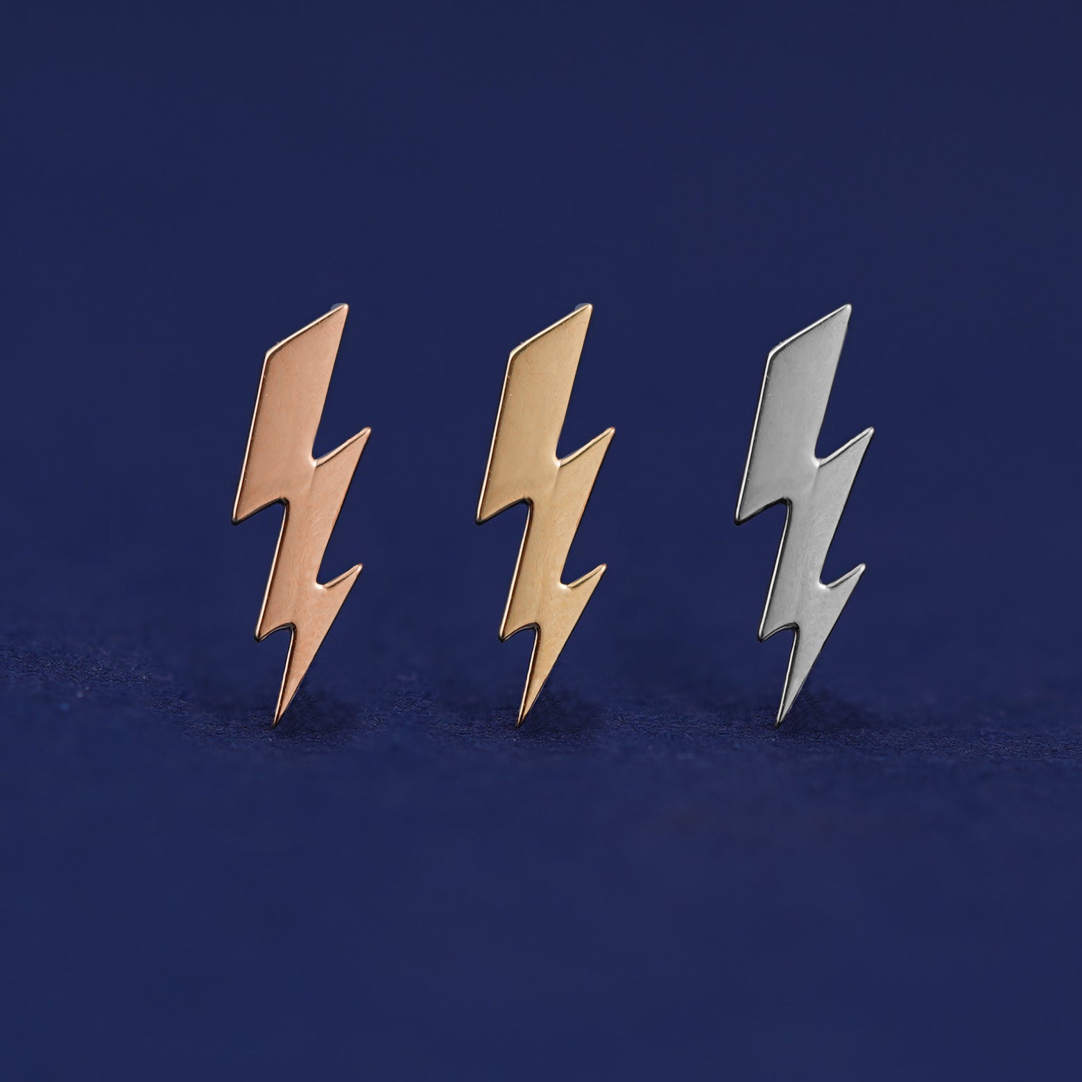 Three versions of the Lightning Bolt Earring shown in options of rose, yellow, and white gold