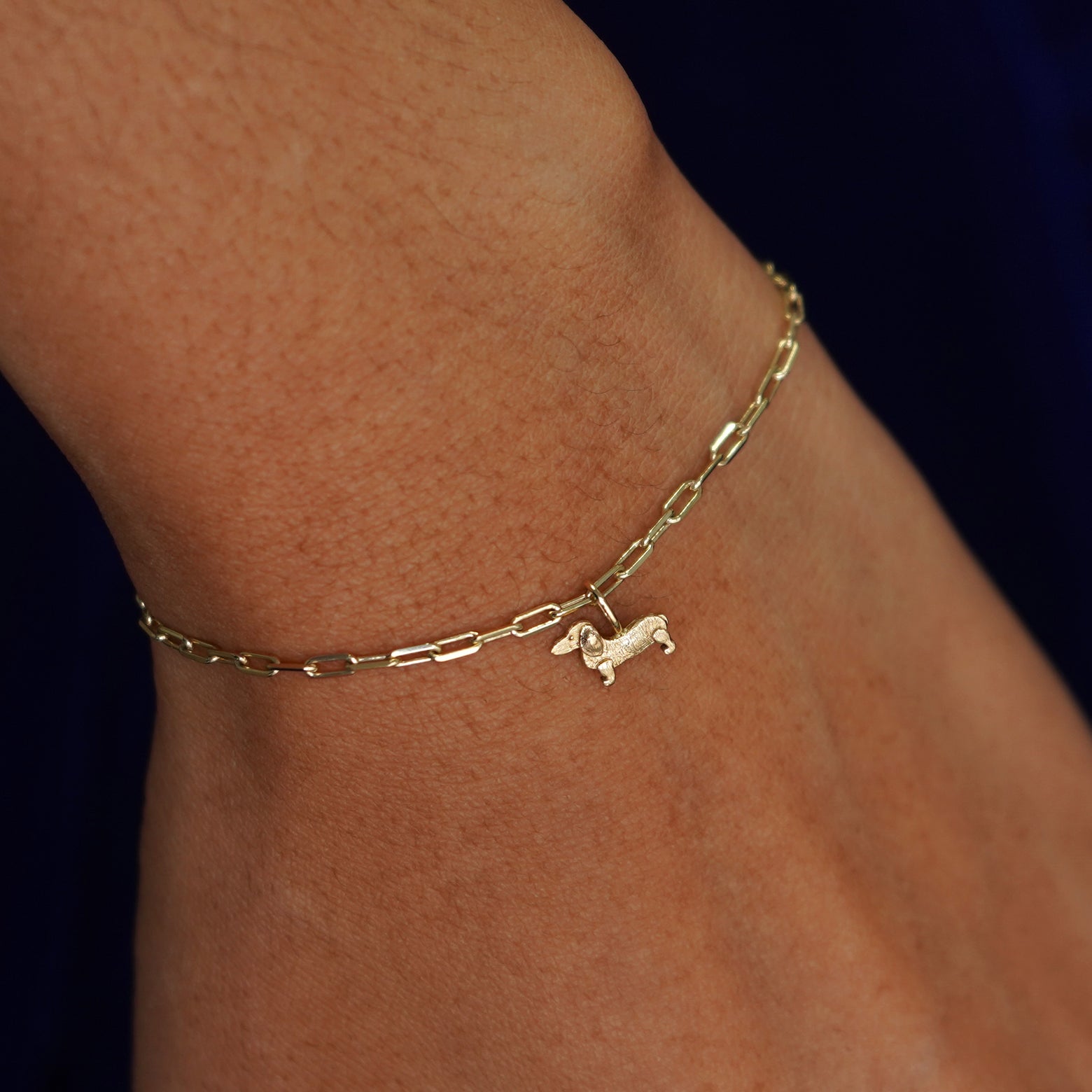 Close up view of a model's wrist wearing a yellow gold Infinity Dog on a Butch Bracelet