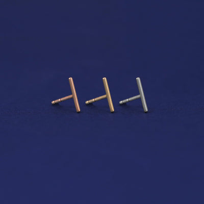 Three versions of the Medium Line Earring shown in options of rose, yellow, and white gold