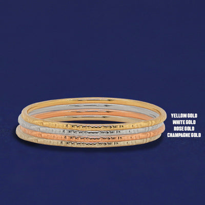 Four versions of the Shimmer Ring shown in options of champagne, white, yellow and rose gold stacked on top each other