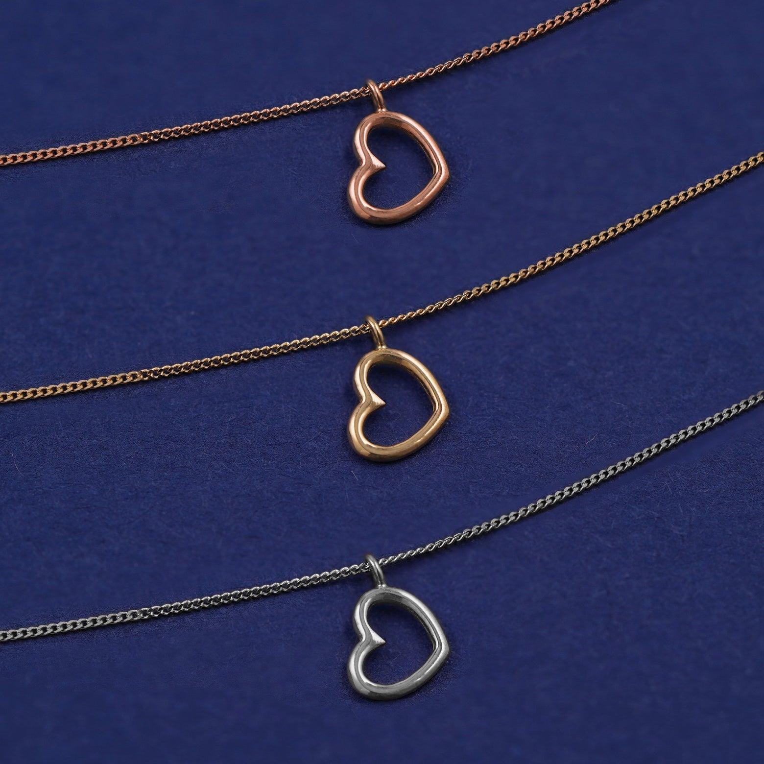 Three Heart Necklaces shown in options of rose, yellow, and white gold