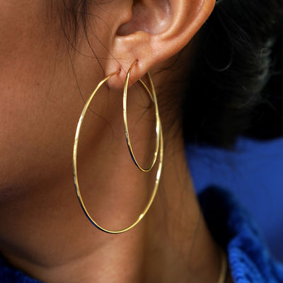 Close up view of a model's ear wearing a Large Endless Hoop and a Small Endless Hoop in two lobe piercings