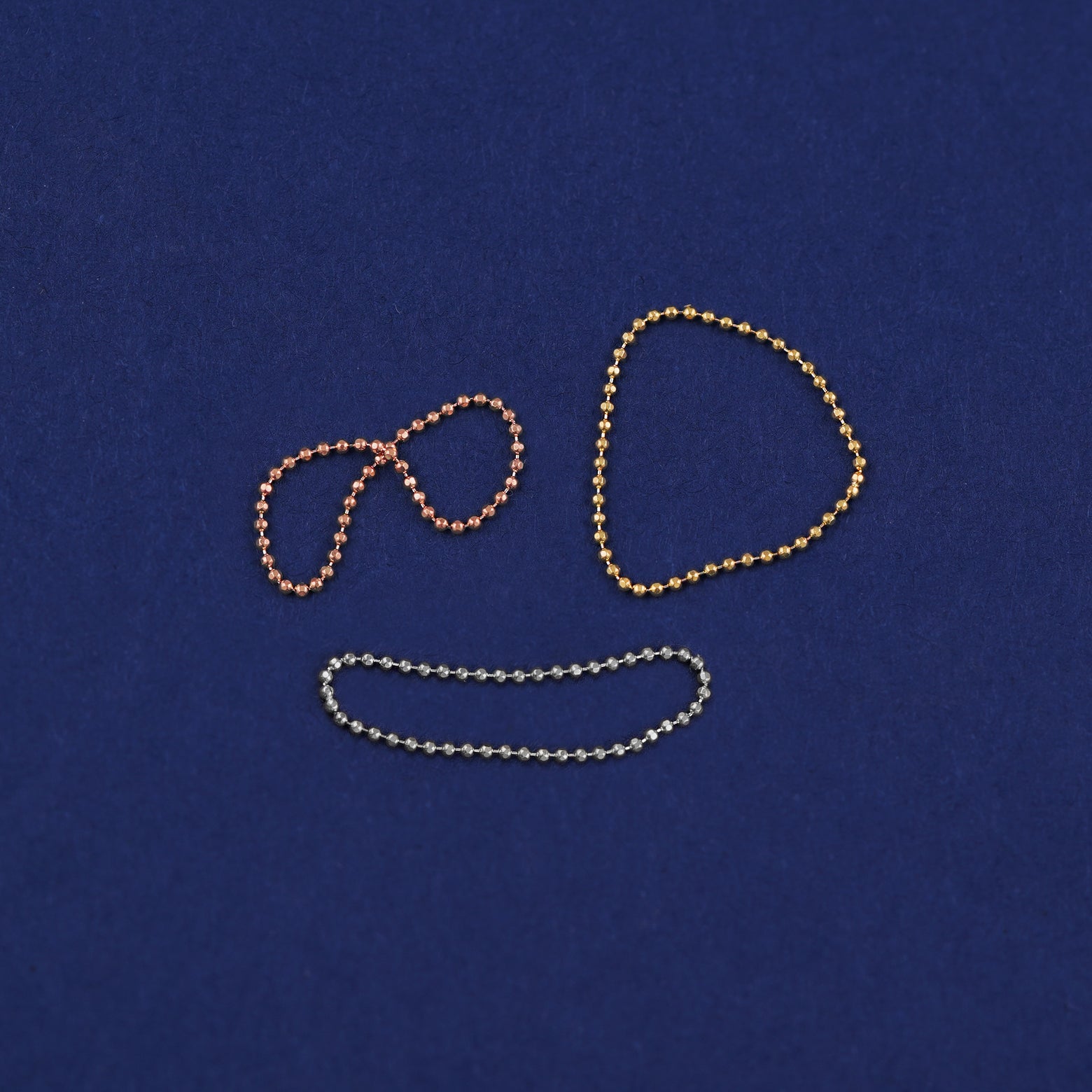 Three versions of the Bead Chain Ring shown in options of yellow, white, and rose gold