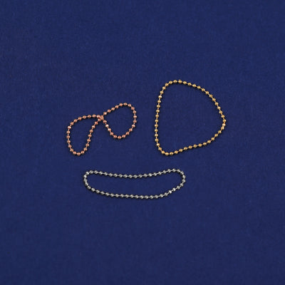 Three versions of the Bead Chain Ring shown in options of yellow, white, and rose gold