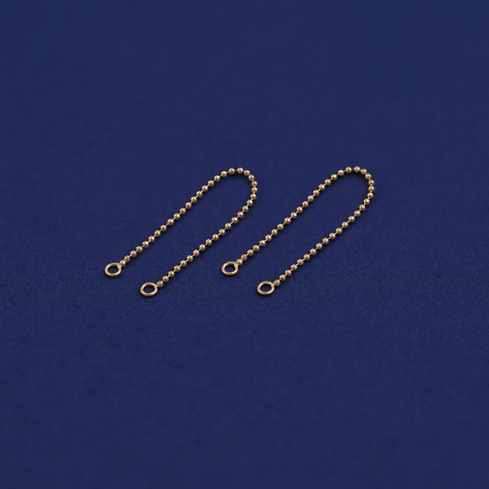 Two yellow gold Connectors laid out to show detail