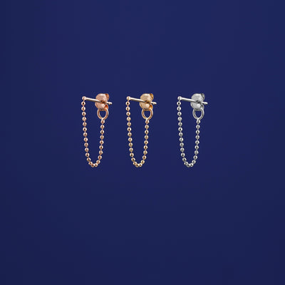 Three versions of the Chain Loop Earring shown in options of rose, yellow, and white gold