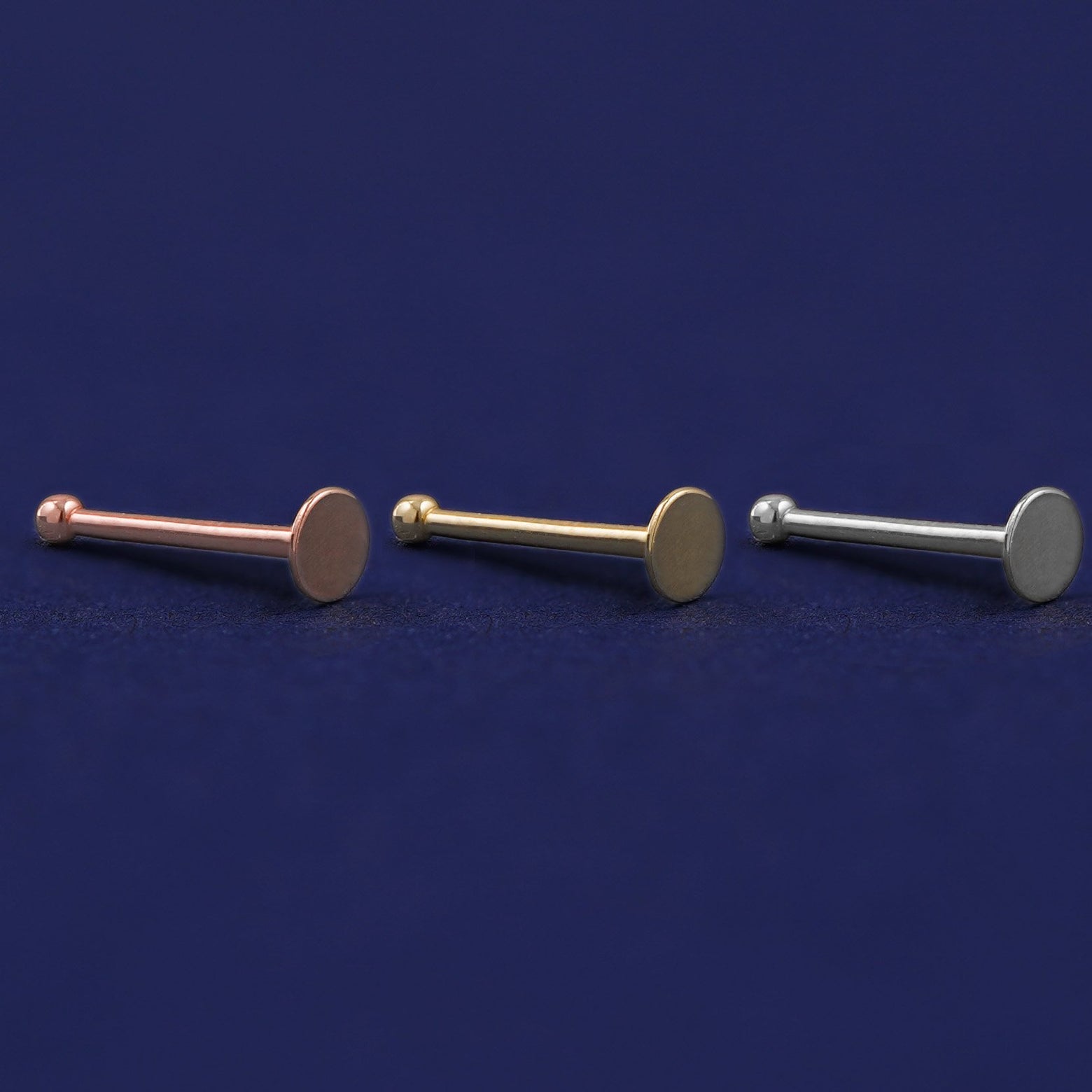 Three versions of the Circle Nose Stud shown in options of rose, yellow, and white gold