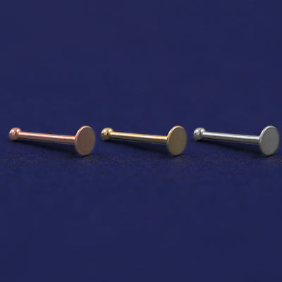 Three versions of the Circle Nose Stud shown in options of rose, yellow, and white gold