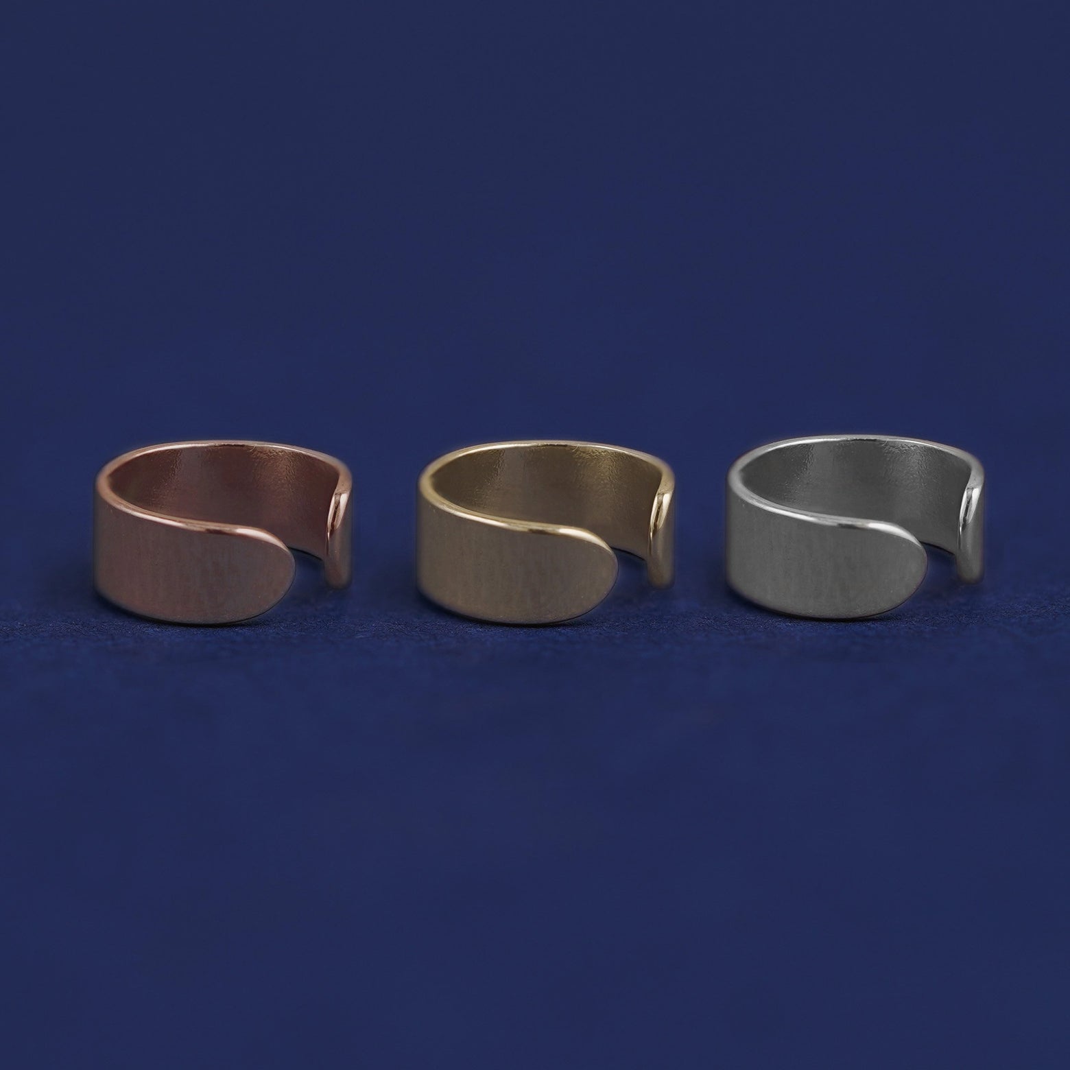 Three versions of the Thick Cuff shown in options of rose, yellow, and white gold