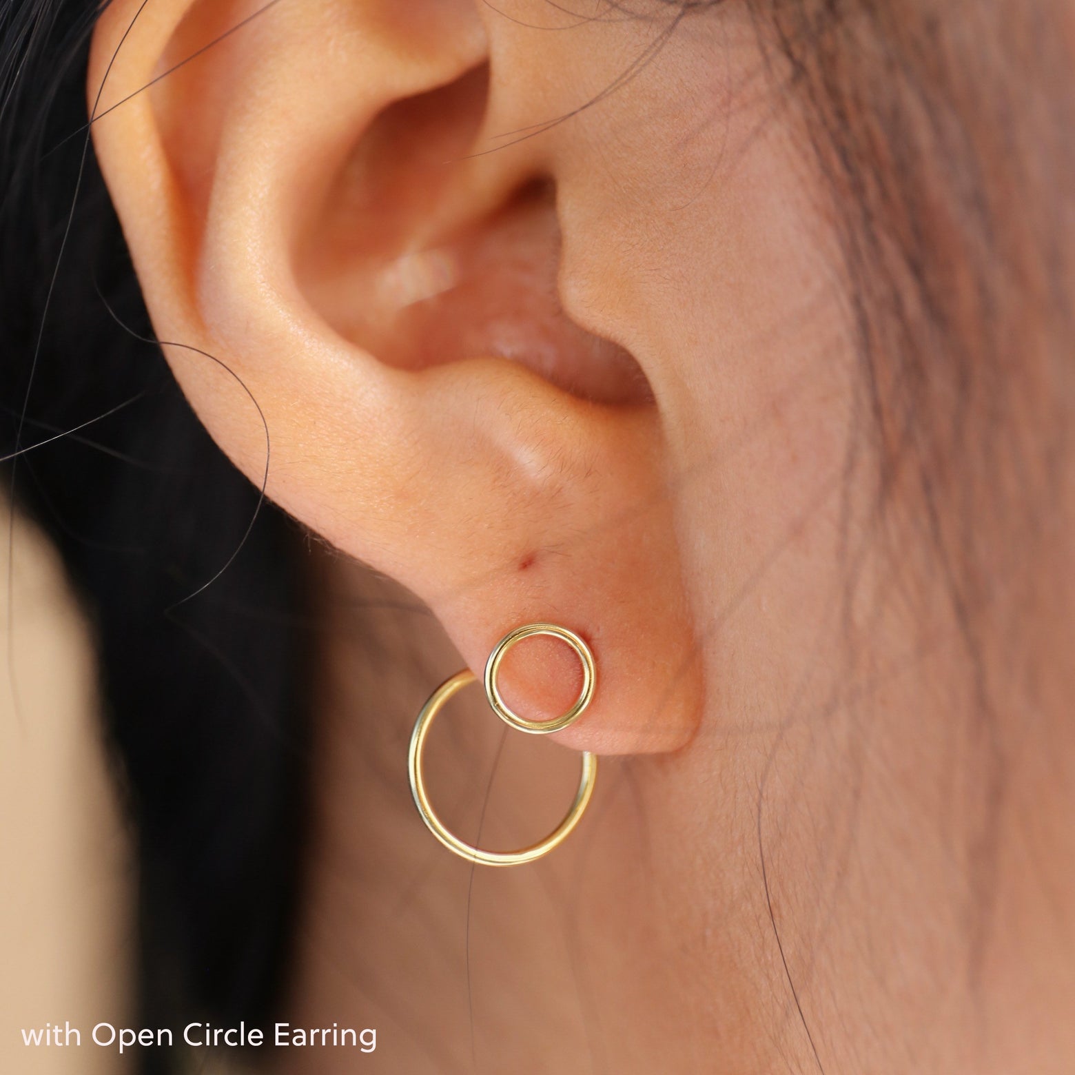 Close up view of a model's ear wearing a yellow gold Open Circle Jacket with an Open Circle Earring