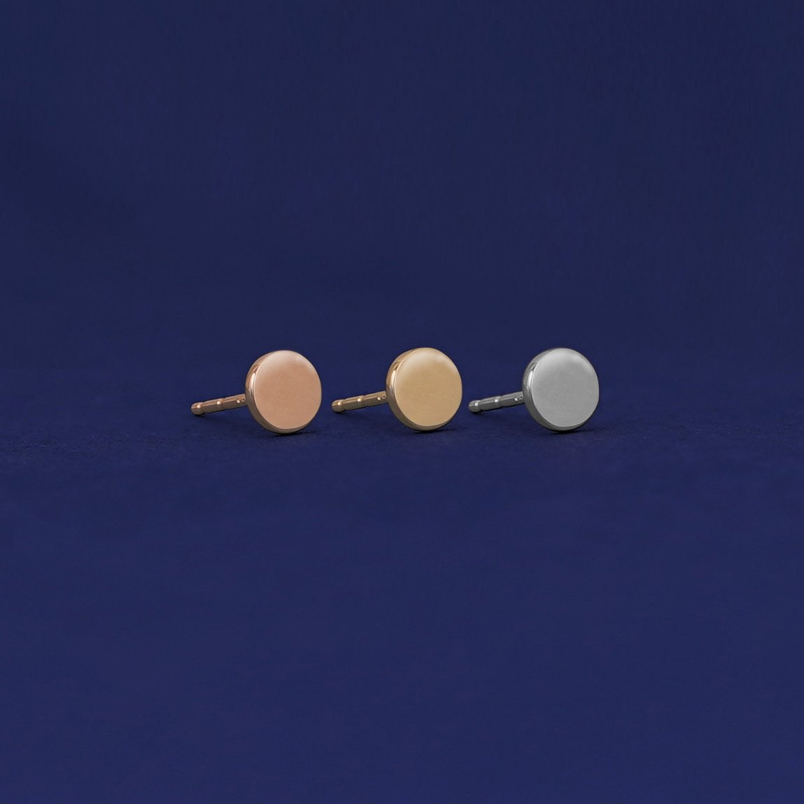 Three versions of the Large Circle Earring shown in options of rose, yellow, and white gold