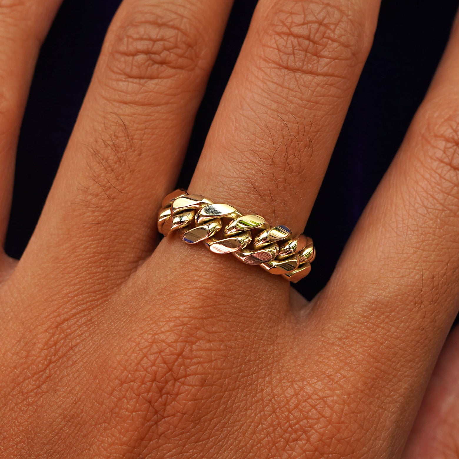 A model's hand wearing a 14 karat gold Miami Cuban Ring