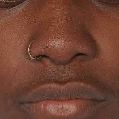 A model's nose wearing a 14 karat gold Nose Ring Hoop