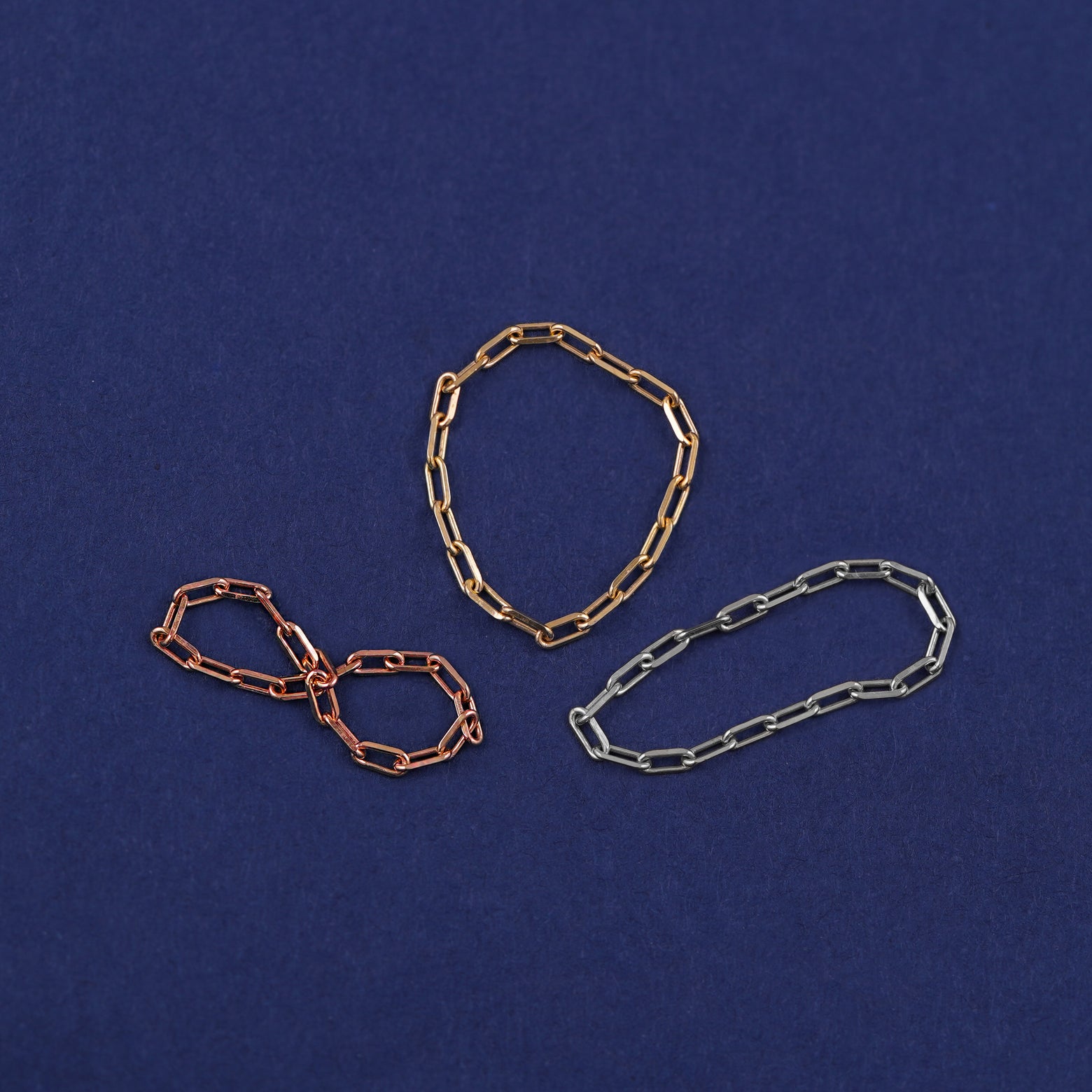 Three versions of the Butch Chain Ring shown in options of rose, yellow, and white gold