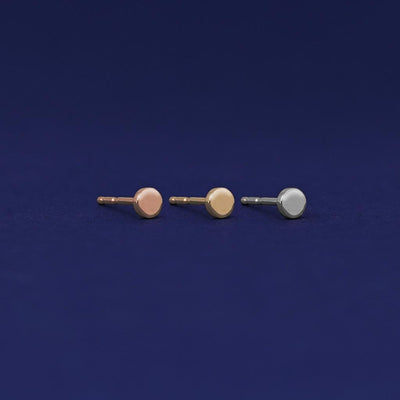 Three versions of the Tiny Circle Earring shown in options of rose, yellow, and white gold