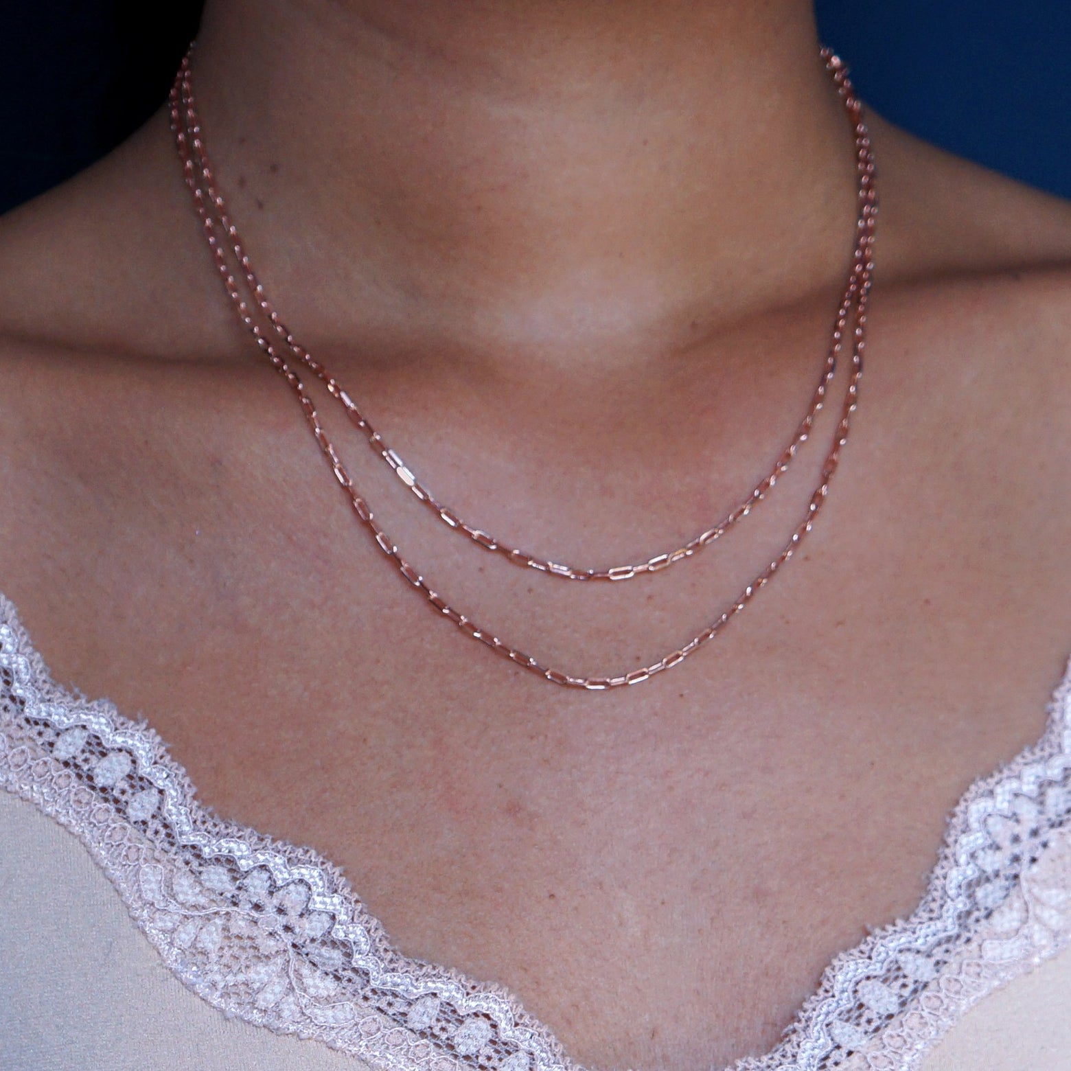 Close up view of a model wearing a 14k rose gold Wrap Necklace doubled to sit just under the collar as a layered necklace