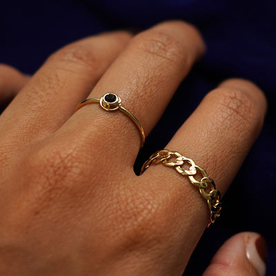 Close up view of a model's hand wearing an Coffee Cup Ring on their middle finger and a Curb Ring on their pointer finger